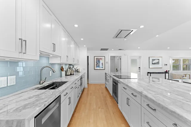 a large kitchen with stainless steel appliances granite countertop a lot of counter space and wooden floors