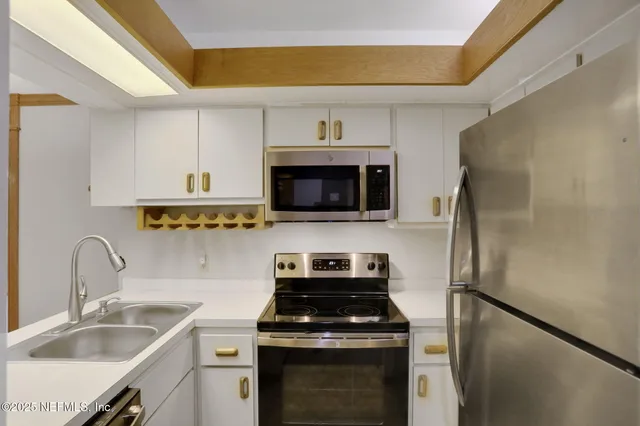 a kitchen with stainless steel appliances a stove a microwave and a sink