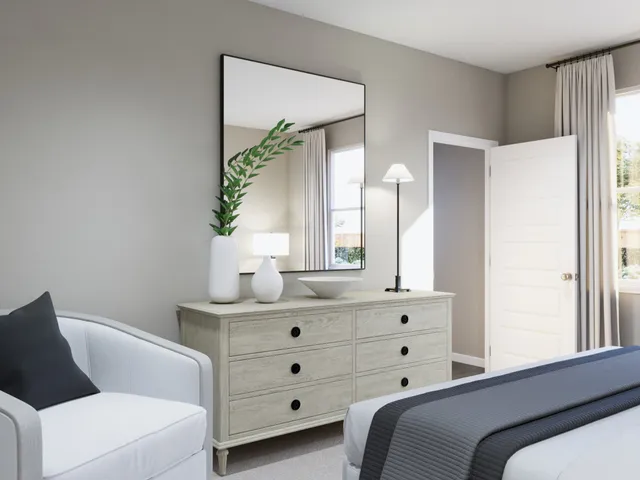 a bedroom with a bed a mirror on dresser and a window