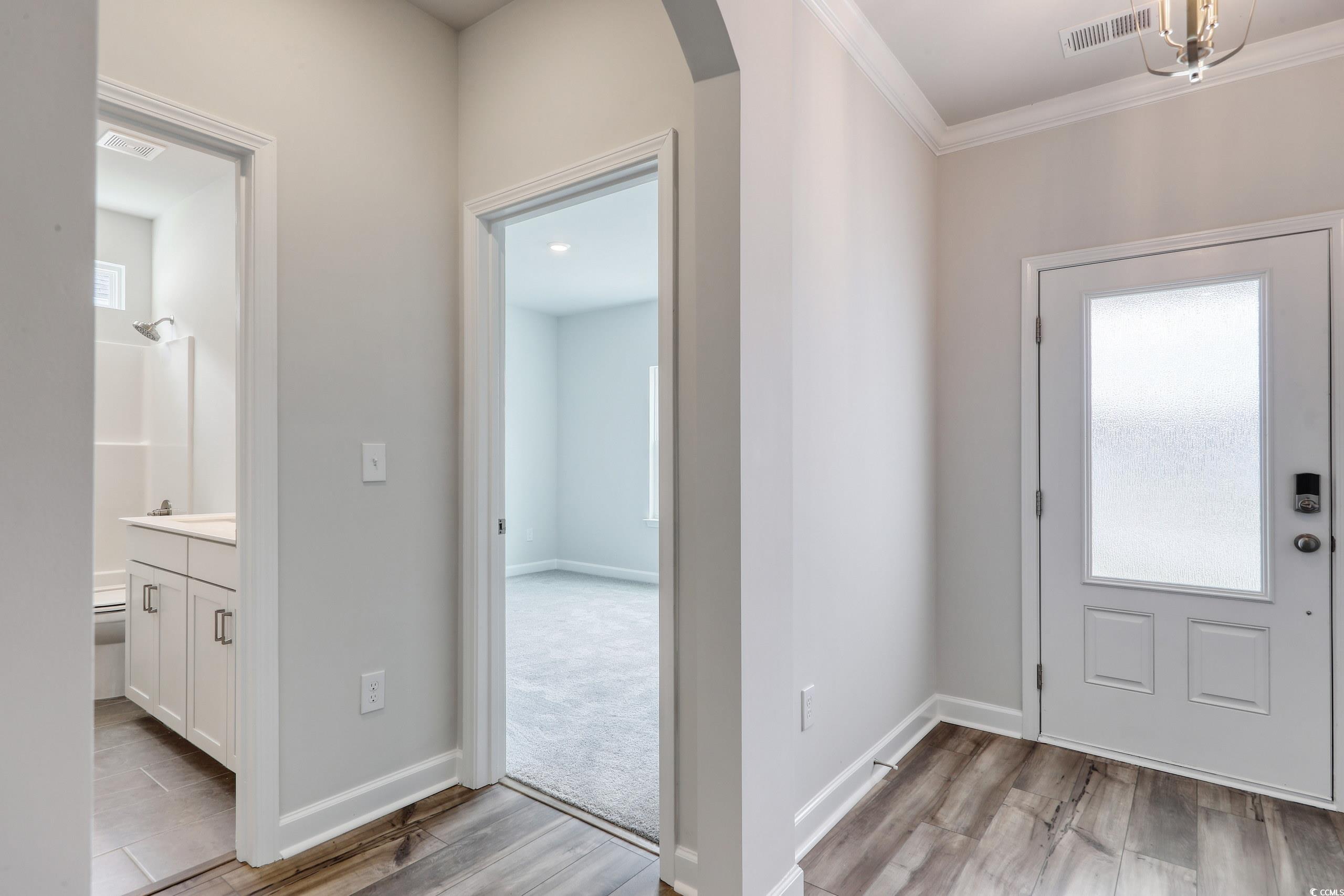 160 Azure Loop Myrtle Beach, SC 29588 - Photo 2 of 36 Entryway with ornamental molding and light hardwoo