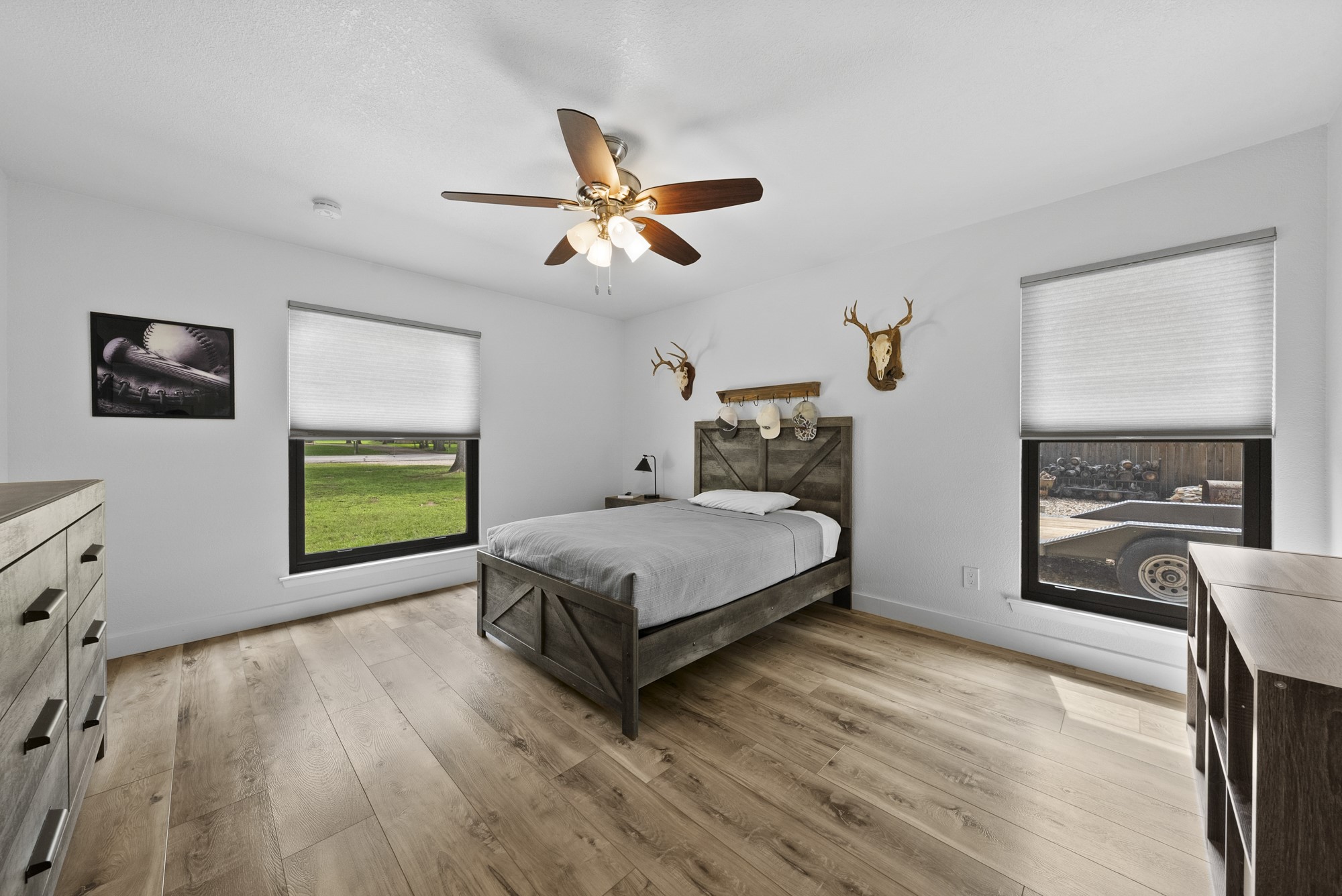 2802 Robin Road Manchaca, TX 78652 - Photo 36 of 40 Bright interior space featuring wood-finish flooring, two windows with blinds, a ceiling fan with integrated lighting, and white walls