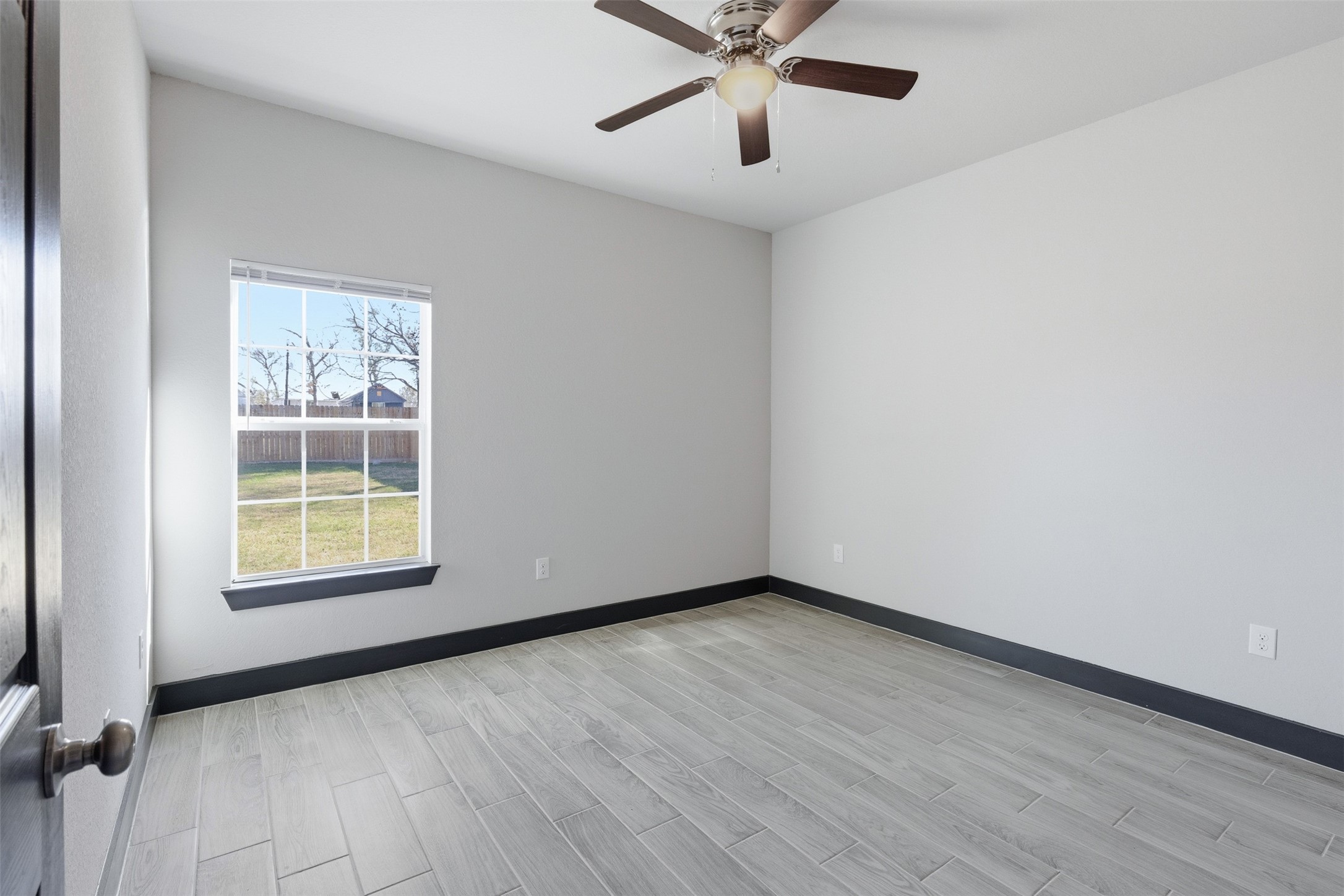 9412 Crofton Street, Unit B Houston, TX 77016 - Photo 15 of 20 a view of an empty room with a window and wooden floor
