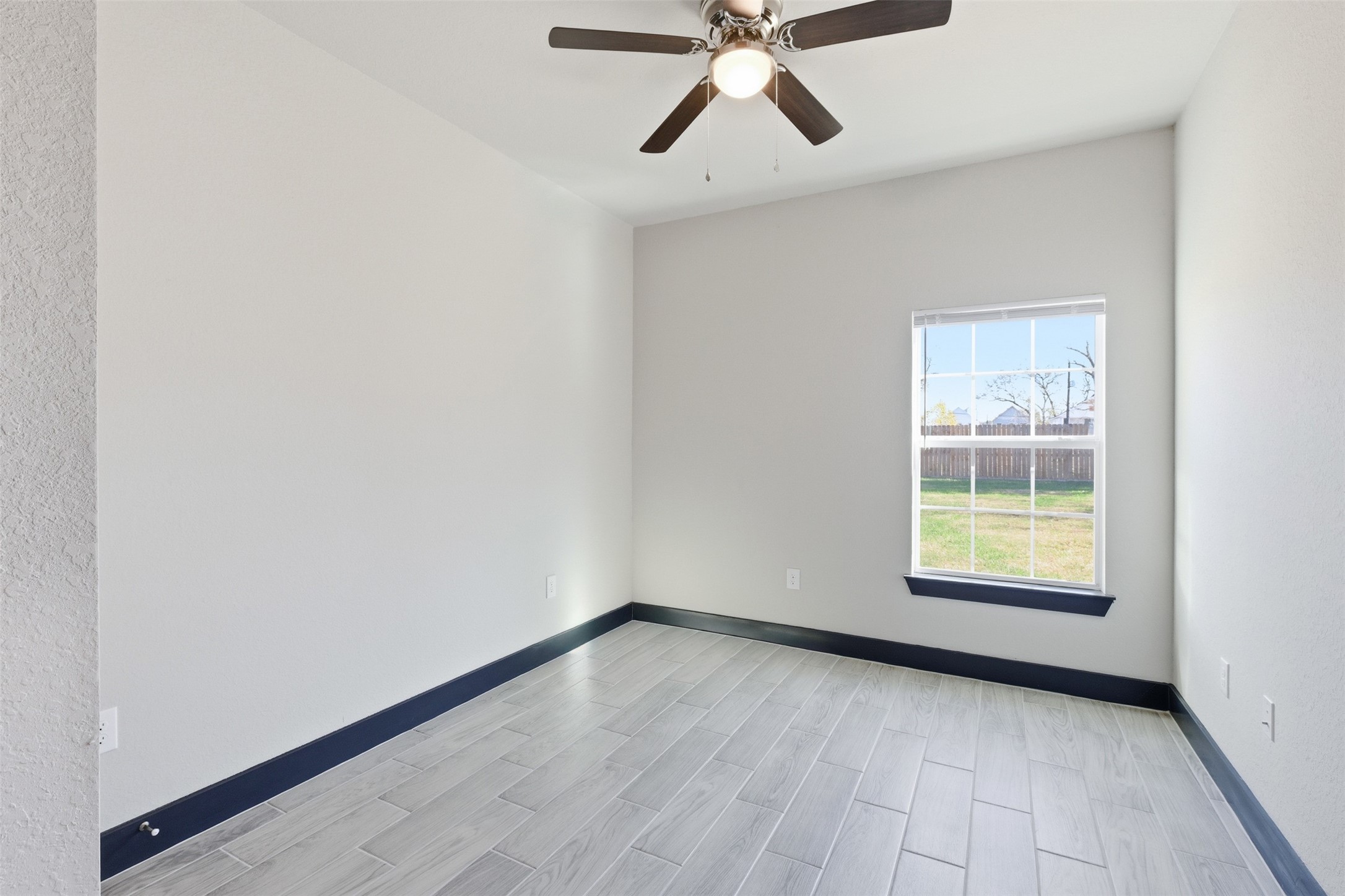 9412 Crofton Street, Unit B Houston, TX 77016 - Photo 17 of 20 an empty room with a window and a fan
