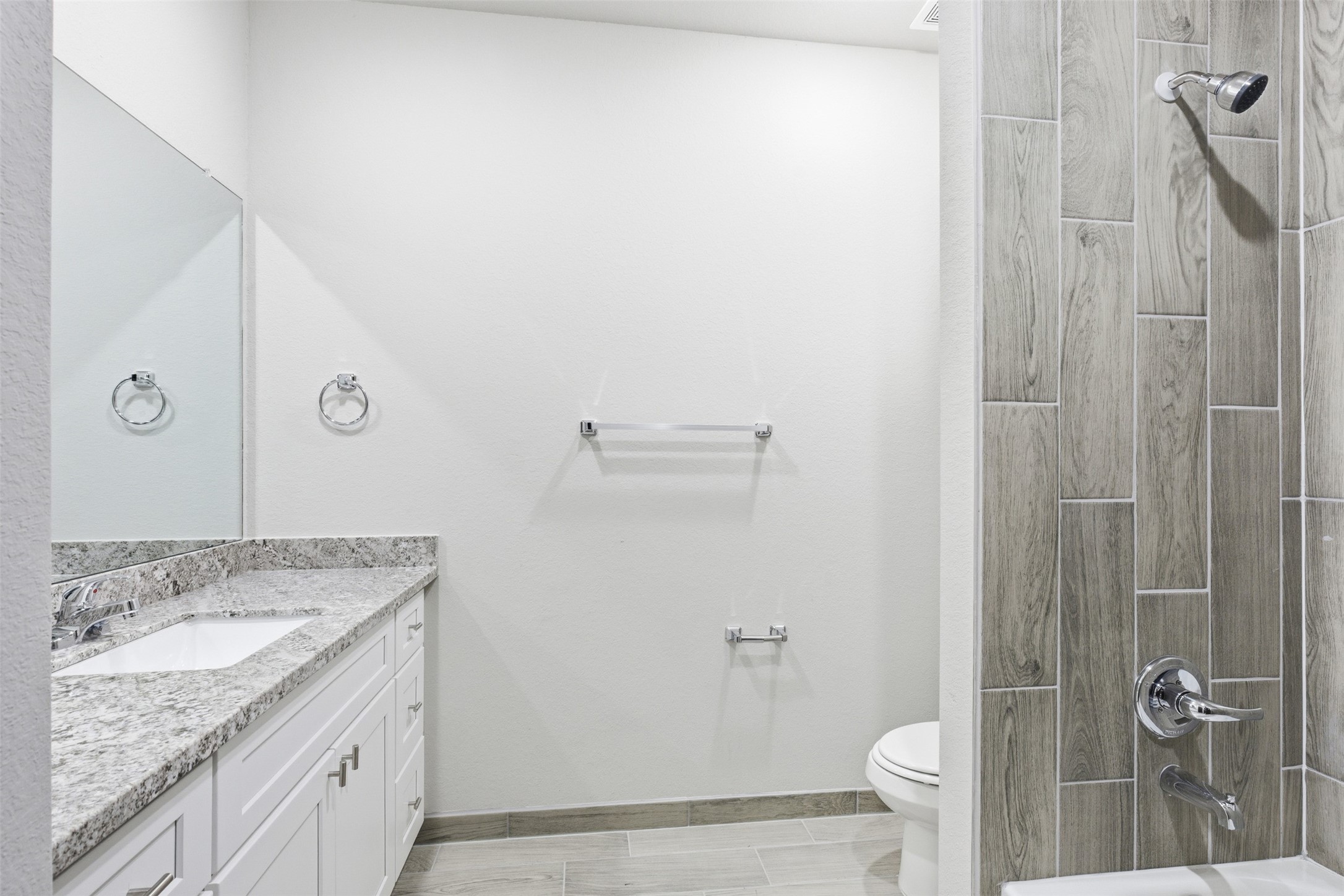 9412 Crofton Street, Unit B Houston, TX 77016 - Photo 19 of 20 a bathroom with a granite countertop sink a toilet and shower