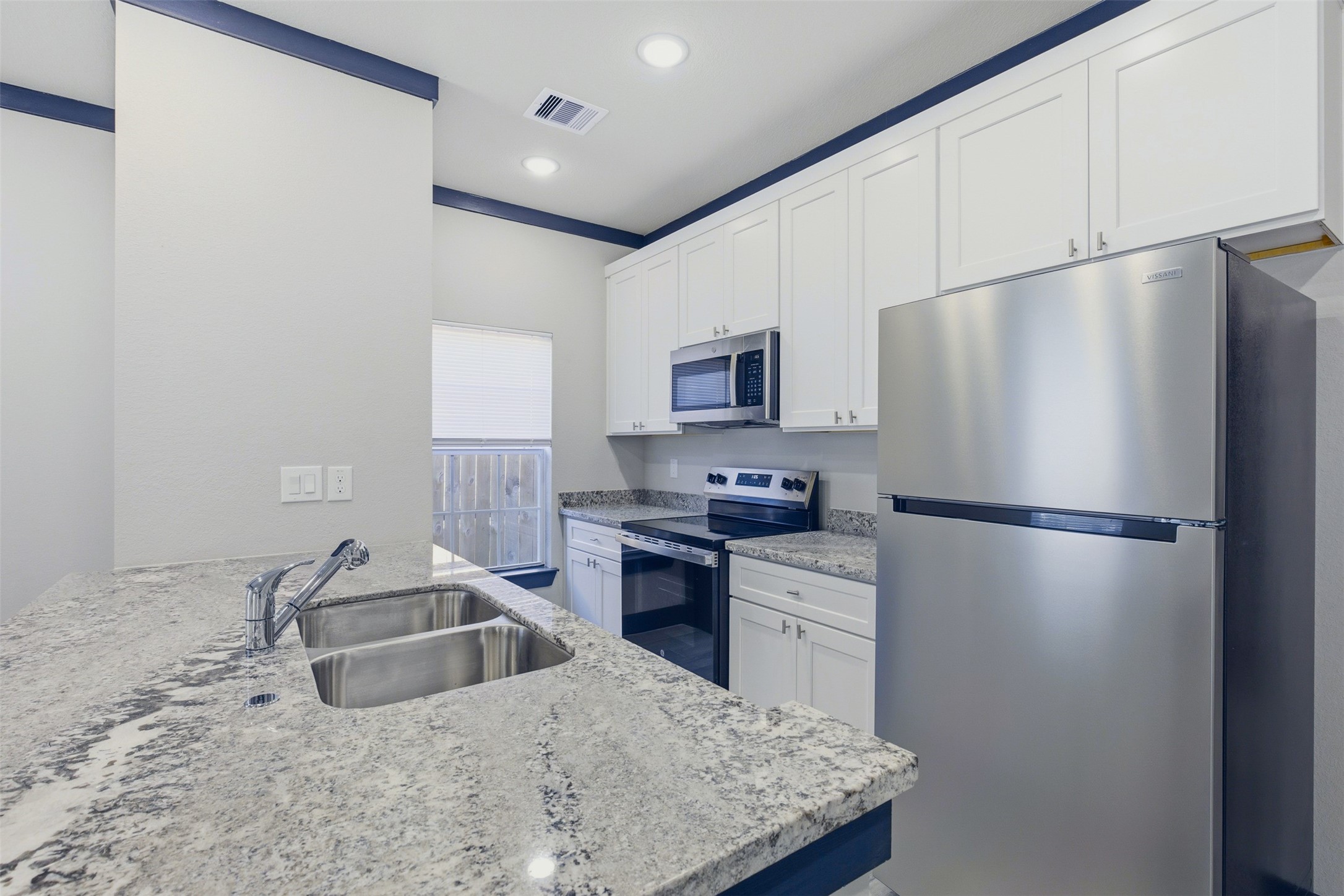 9412 Crofton Street, Unit B Houston, TX 77016 - Photo 5 of 20 a kitchen with stainless steel appliances granite countertop a refrigerator a stove a sink and a granite counter tops