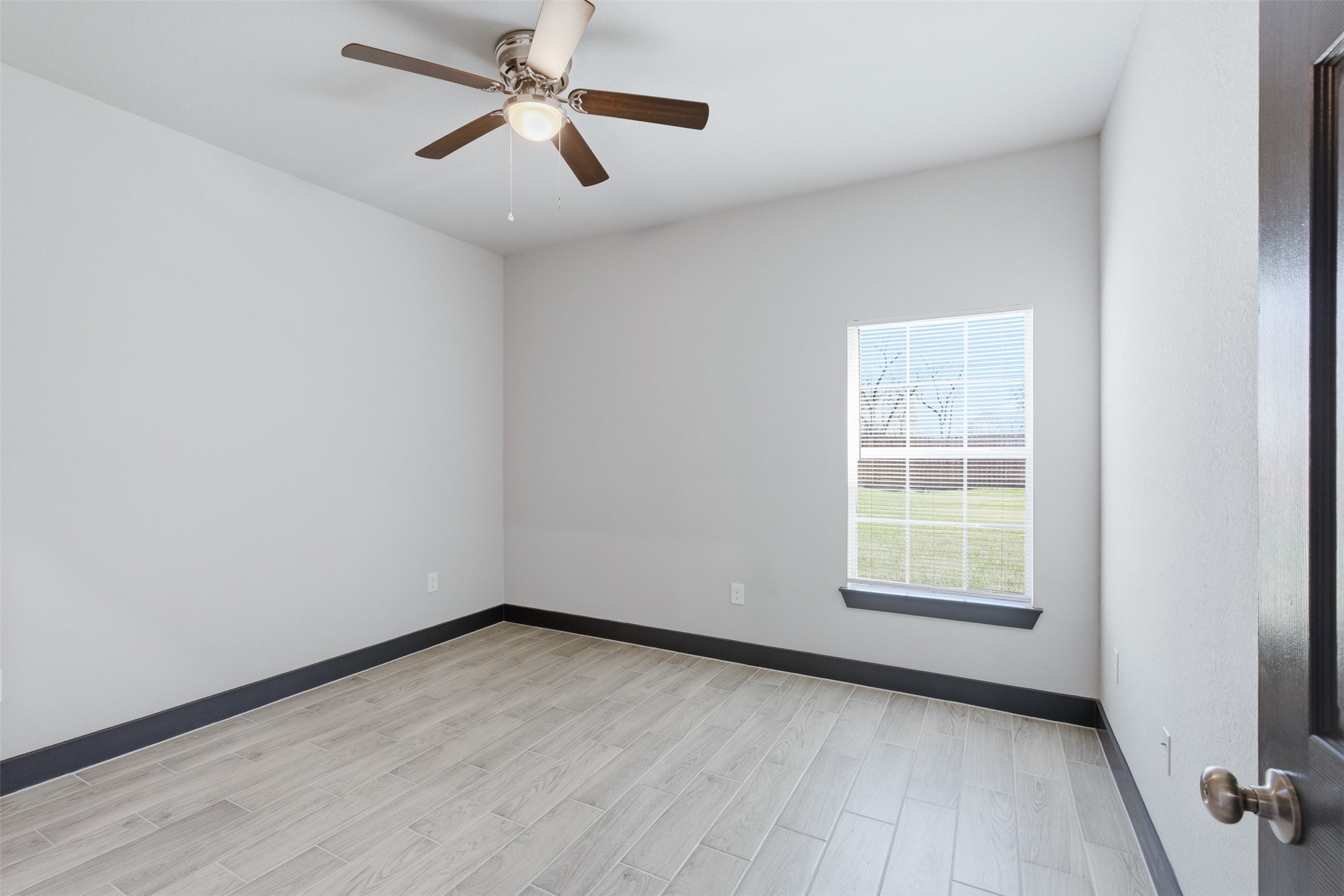 9412 Crofton Street, Unit B Houston, TX 77016 - Photo 6 of 20 an empty room with windows and fan