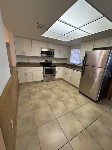 a kitchen with stainless steel appliances cabinets and a counter top space