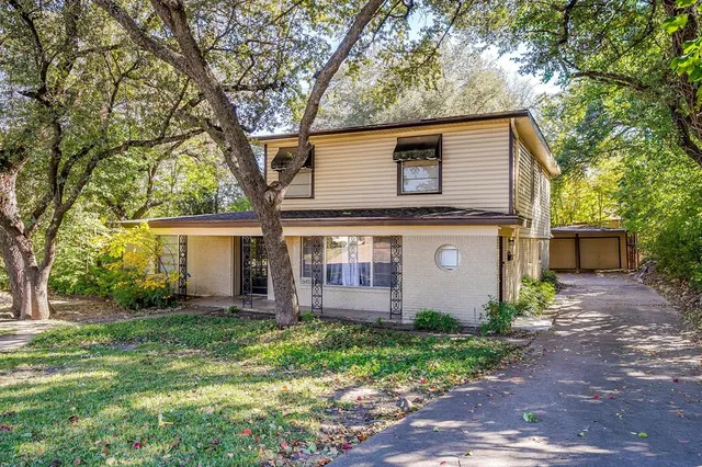 a view of a house with yard and tree s