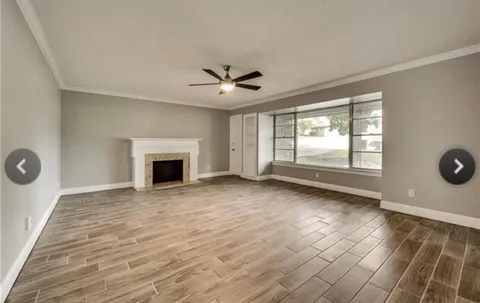 an empty room with windows and a fireplace