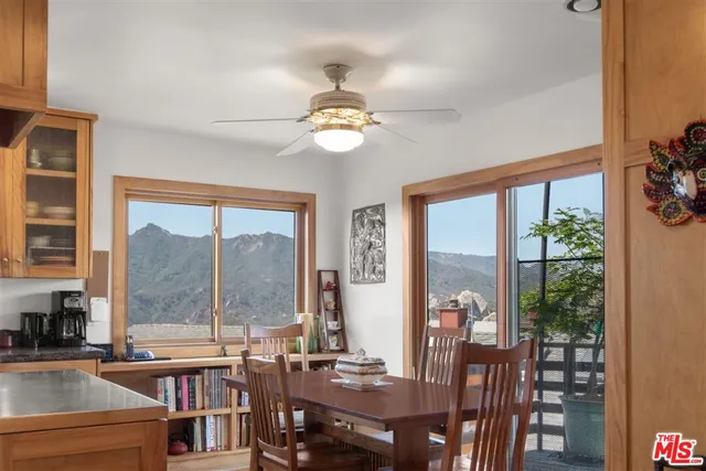 a view of a dining room with furniture large windows and wooden floor