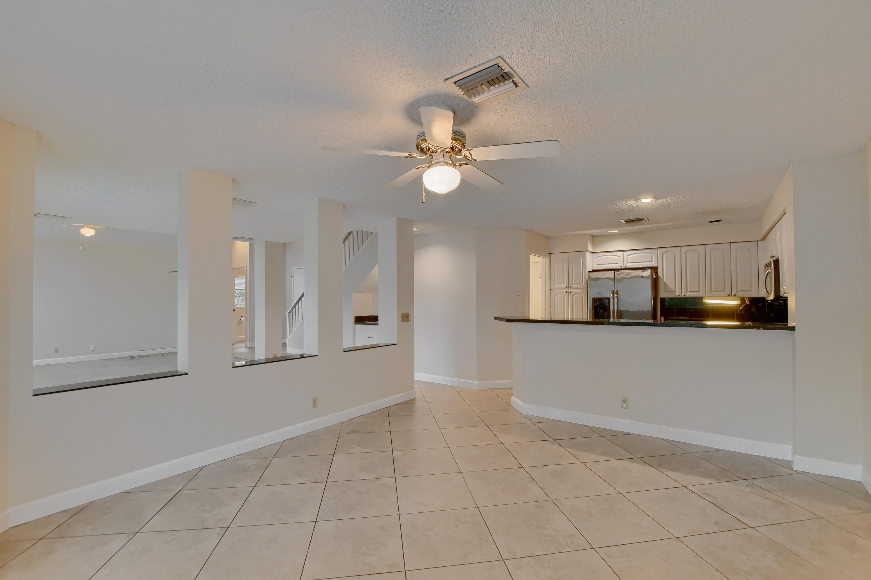 2252 Northwest 53rd Street Boca Raton, FL 33496 - Photo 14 of 41 a view of a kitchen with an empty space and a ceiling fan