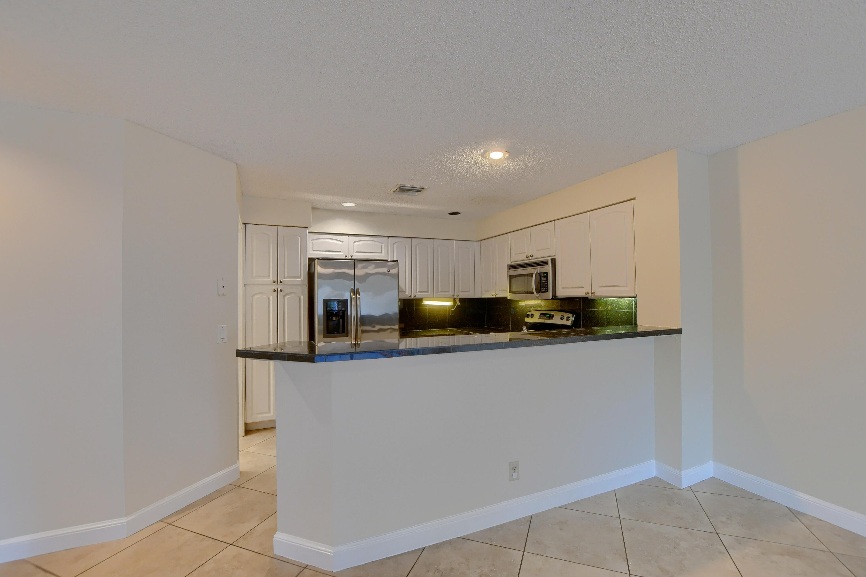 2252 Northwest 53rd Street Boca Raton, FL 33496 - Photo 15 of 41 a kitchen with stainless steel appliances a sink a stove top oven a counter top space and cabinets