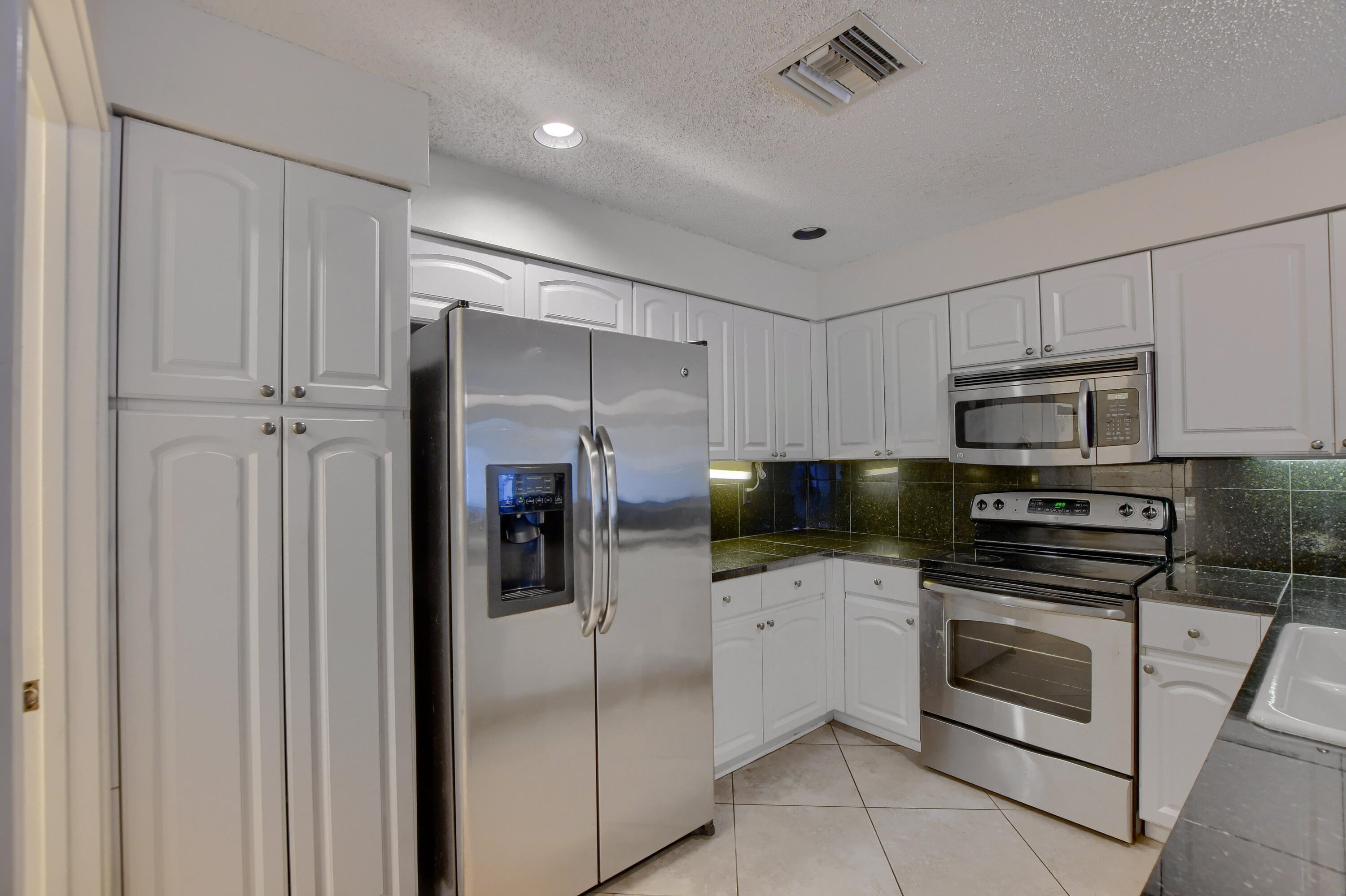 2252 Northwest 53rd Street Boca Raton, FL 33496 - Photo 16 of 41 a kitchen with stainless steel appliances granite countertop a refrigerator and a stove top oven