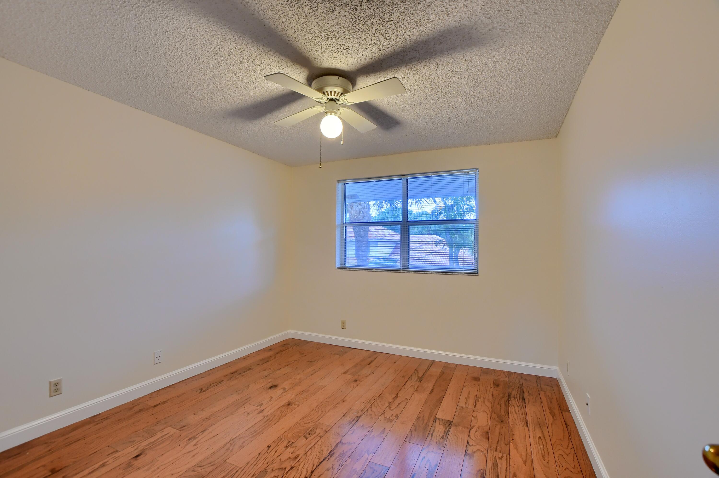 2252 Northwest 53rd Street Boca Raton, FL 33496 - Photo 30 of 41 an empty room with wooden floor fan and windows