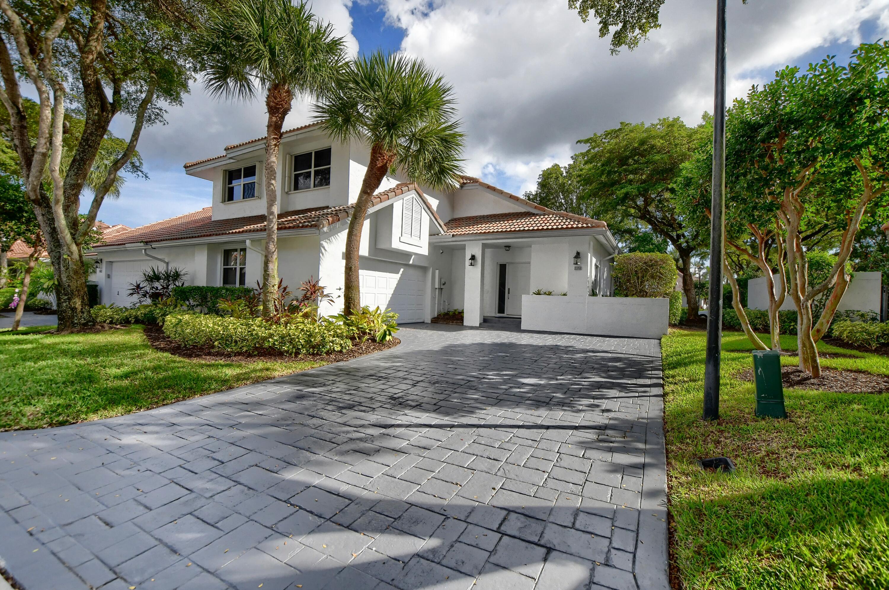 2252 Northwest 53rd Street Boca Raton, FL 33496 - Photo 3 of 41 a view of a white house next to a yard with big trees