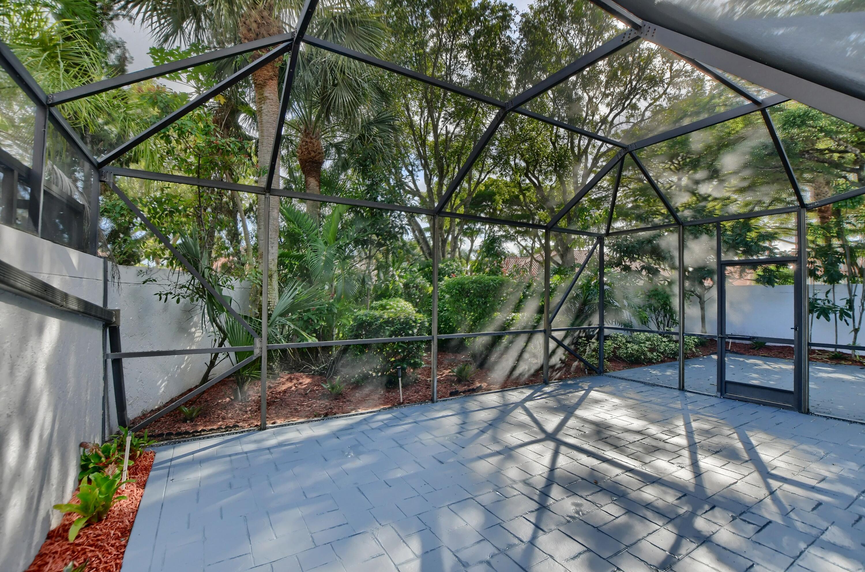 2252 Northwest 53rd Street Boca Raton, FL 33496 - Photo 40 of 41 a backyard of a house with lots of green space and outdoor seating