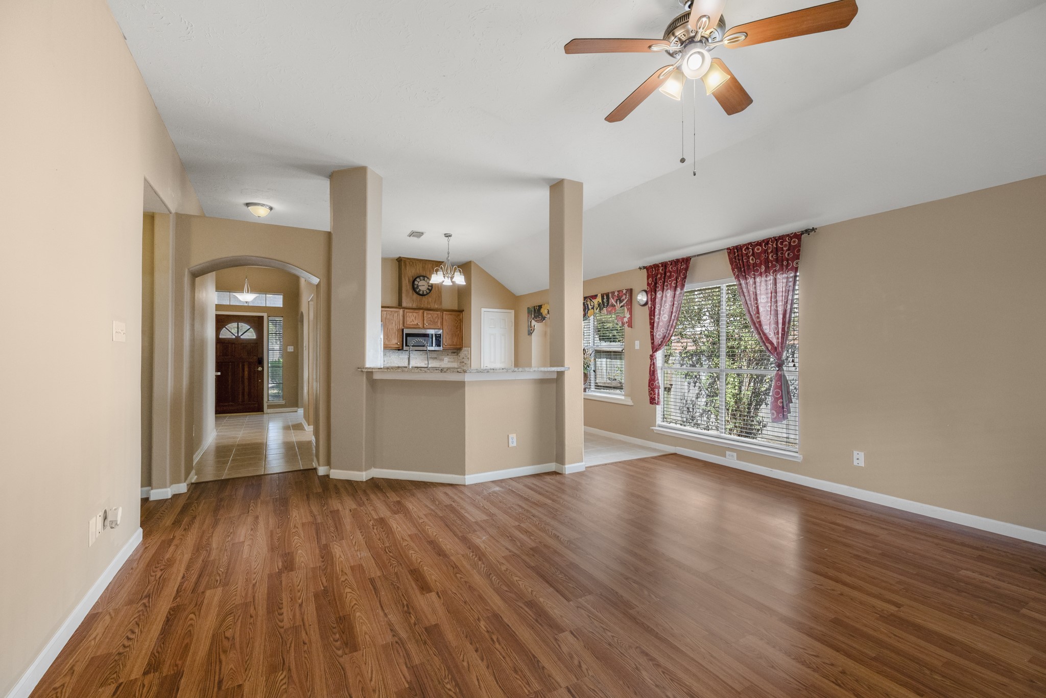 9109 Benwick Street Spring, TX 77379 - Photo 13 of 28 a view of a room with wooden floor a ceiling fan and windows