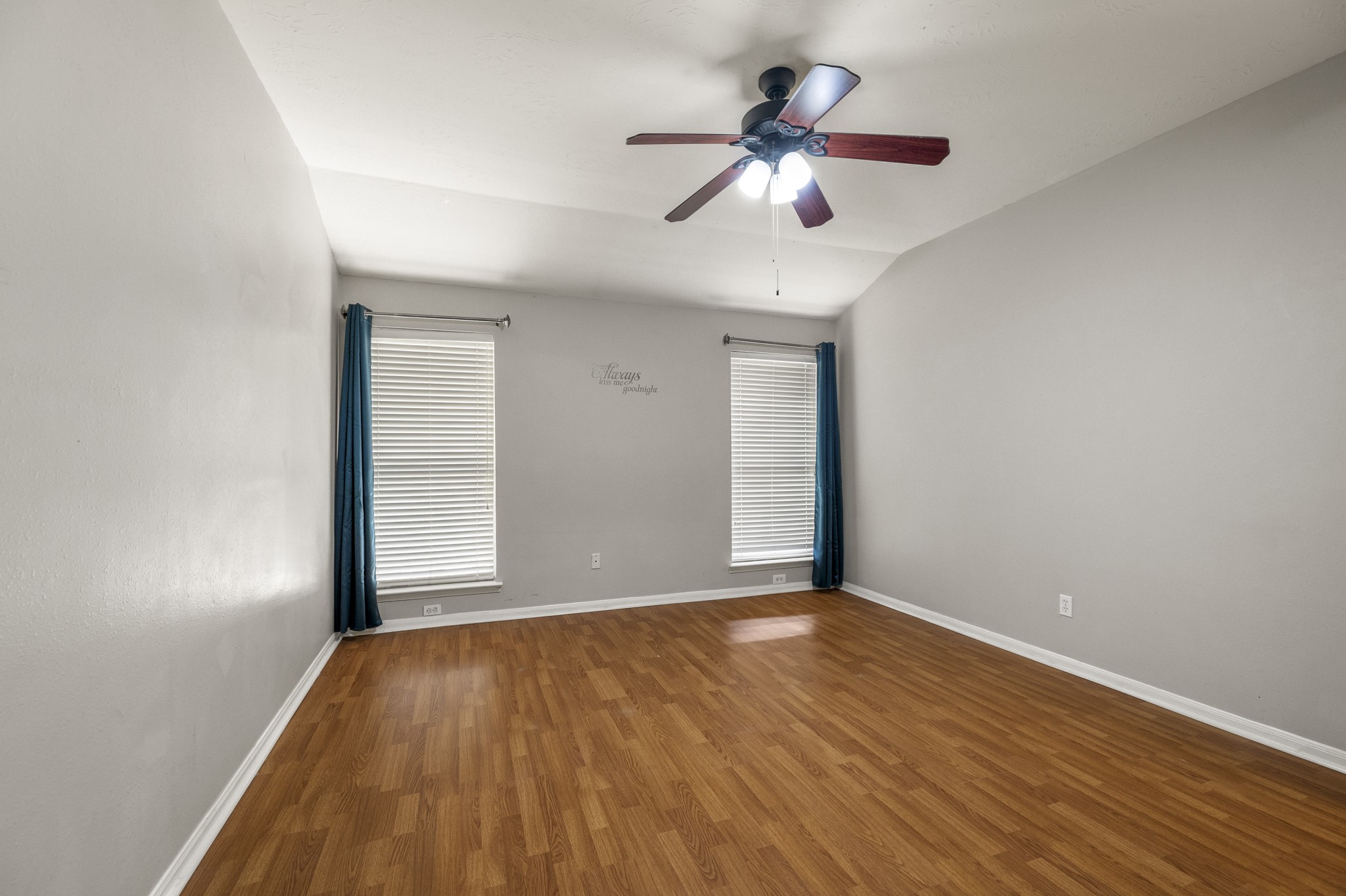 9109 Benwick Street Spring, TX 77379 - Photo 15 of 28 an empty room with wooden floor chandelier fan and windows