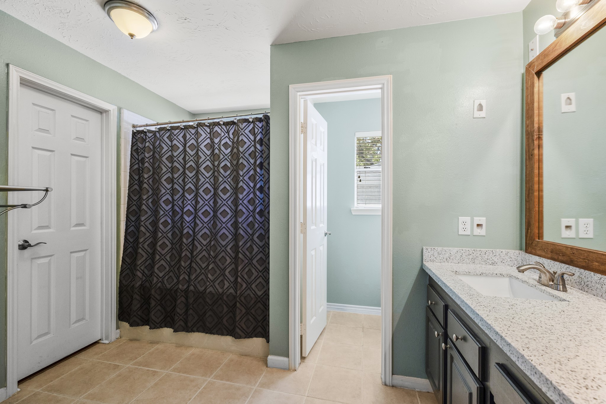 9109 Benwick Street Spring, TX 77379 - Photo 17 of 28 a bathroom with a granite countertop sink and a mirror