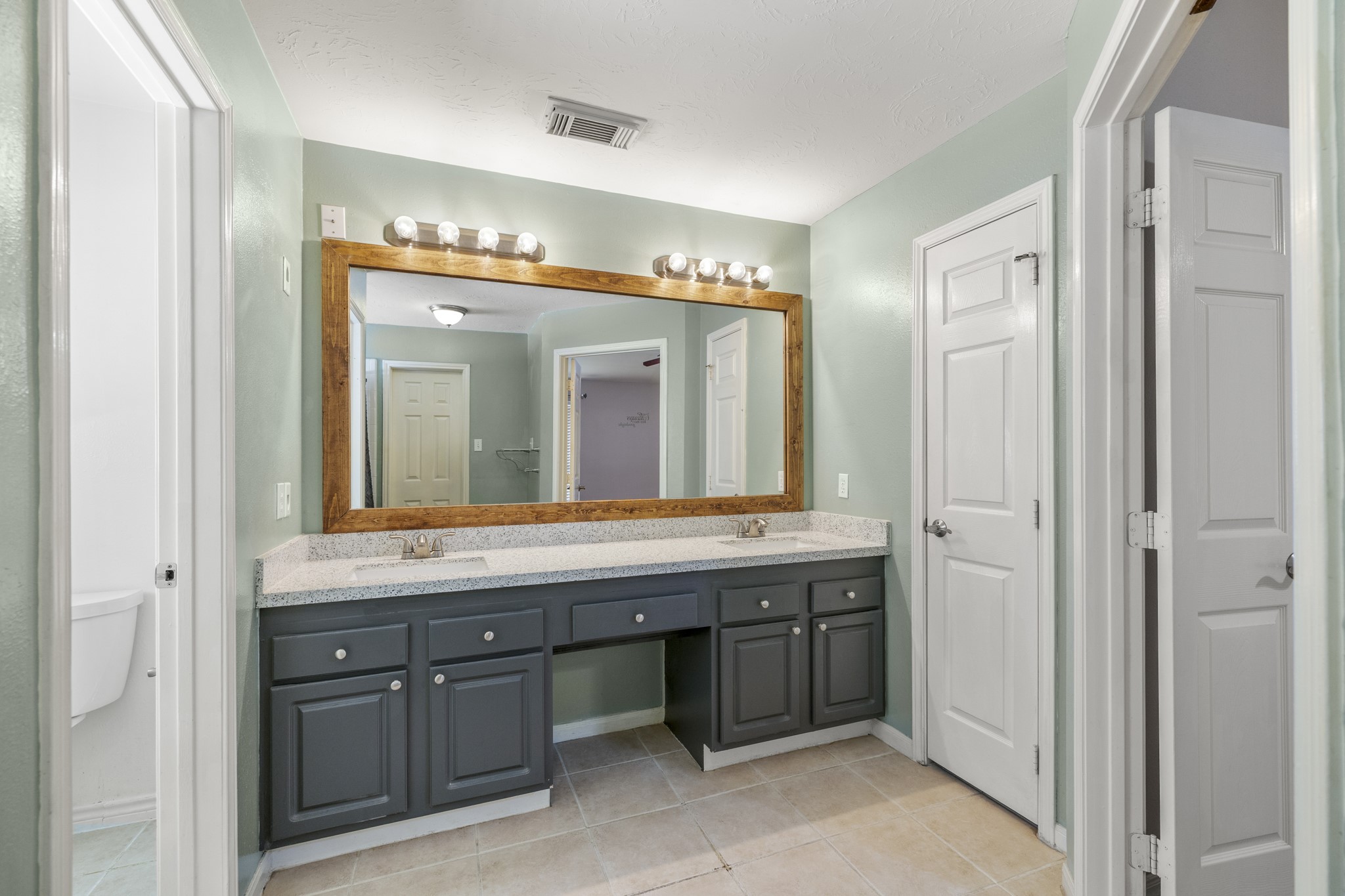 9109 Benwick Street Spring, TX 77379 - Photo 18 of 28 a bathroom with a granite countertop sink and a mirror