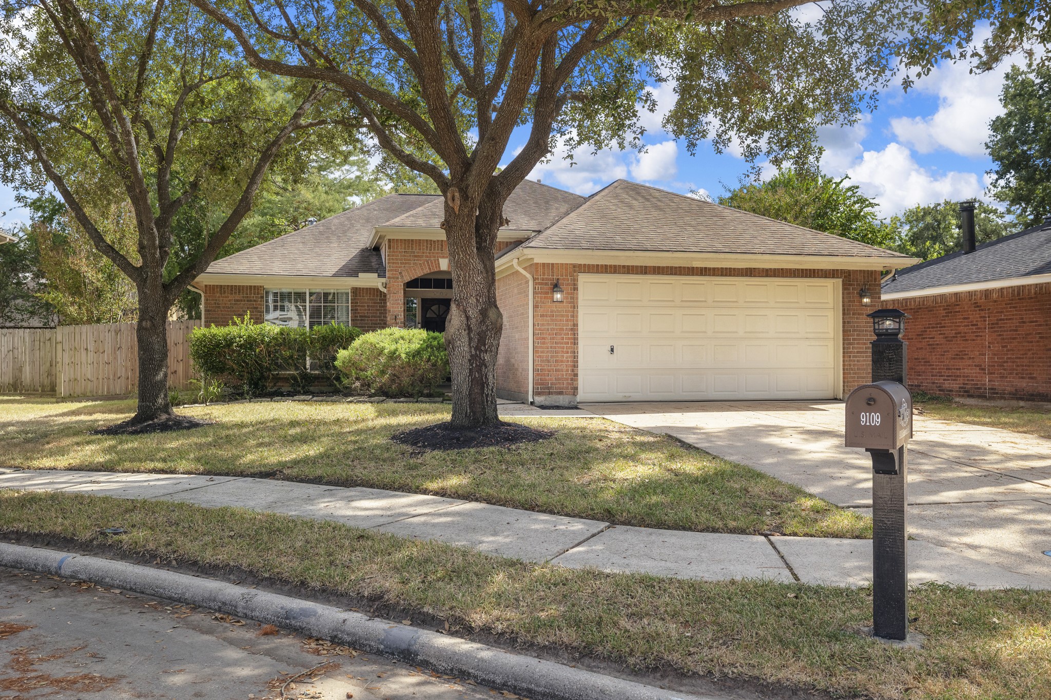 9109 Benwick Street Spring, TX 77379 - Photo 2 of 28 a front view of a house with a yard and garage