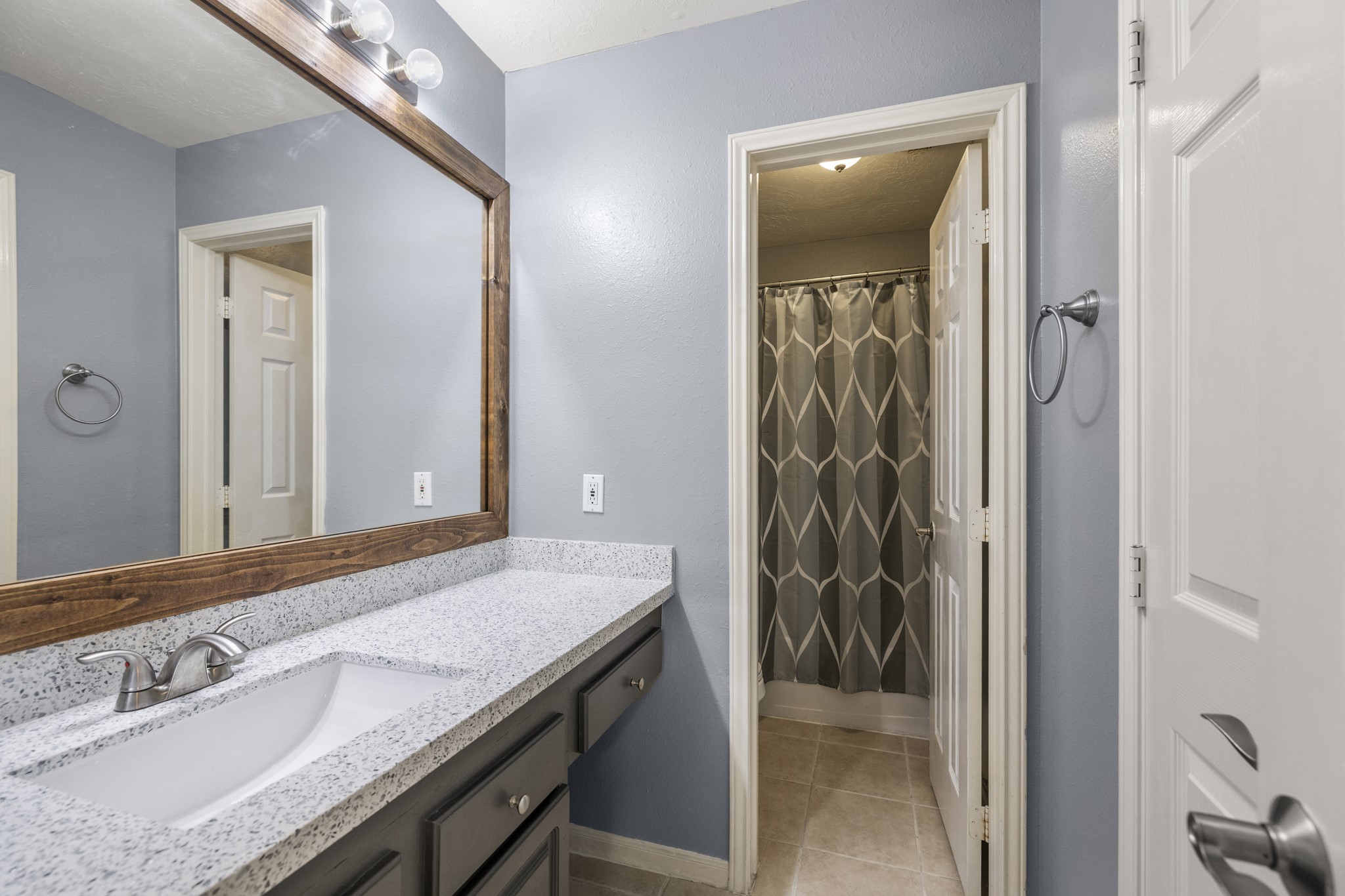 9109 Benwick Street Spring, TX 77379 - Photo 21 of 28 a bathroom with a granite countertop sink and a mirror