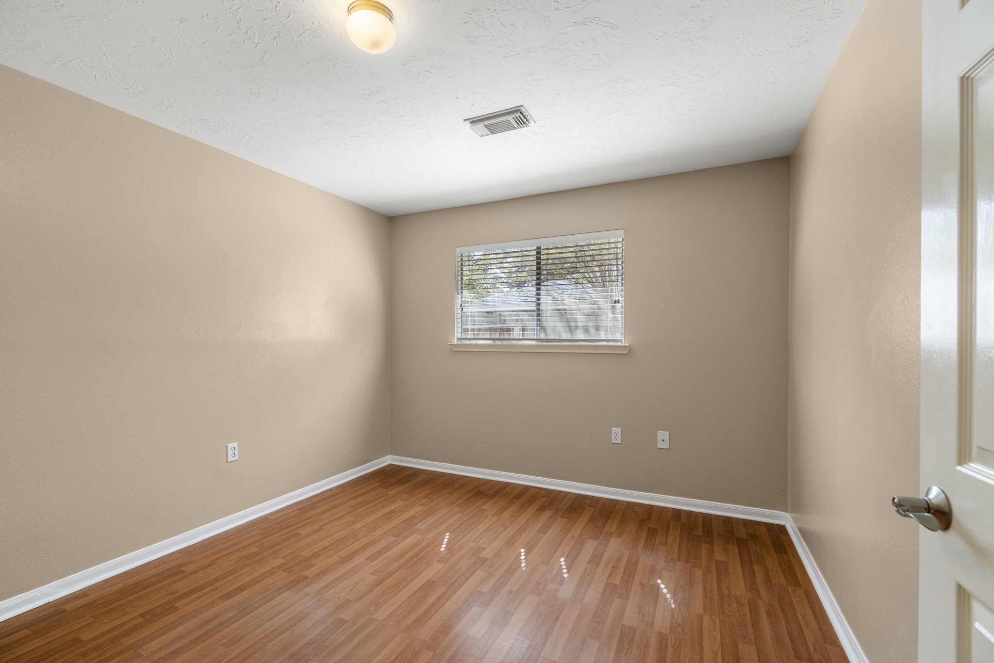9109 Benwick Street Spring, TX 77379 - Photo 22 of 28 an empty room with wooden floor and windows
