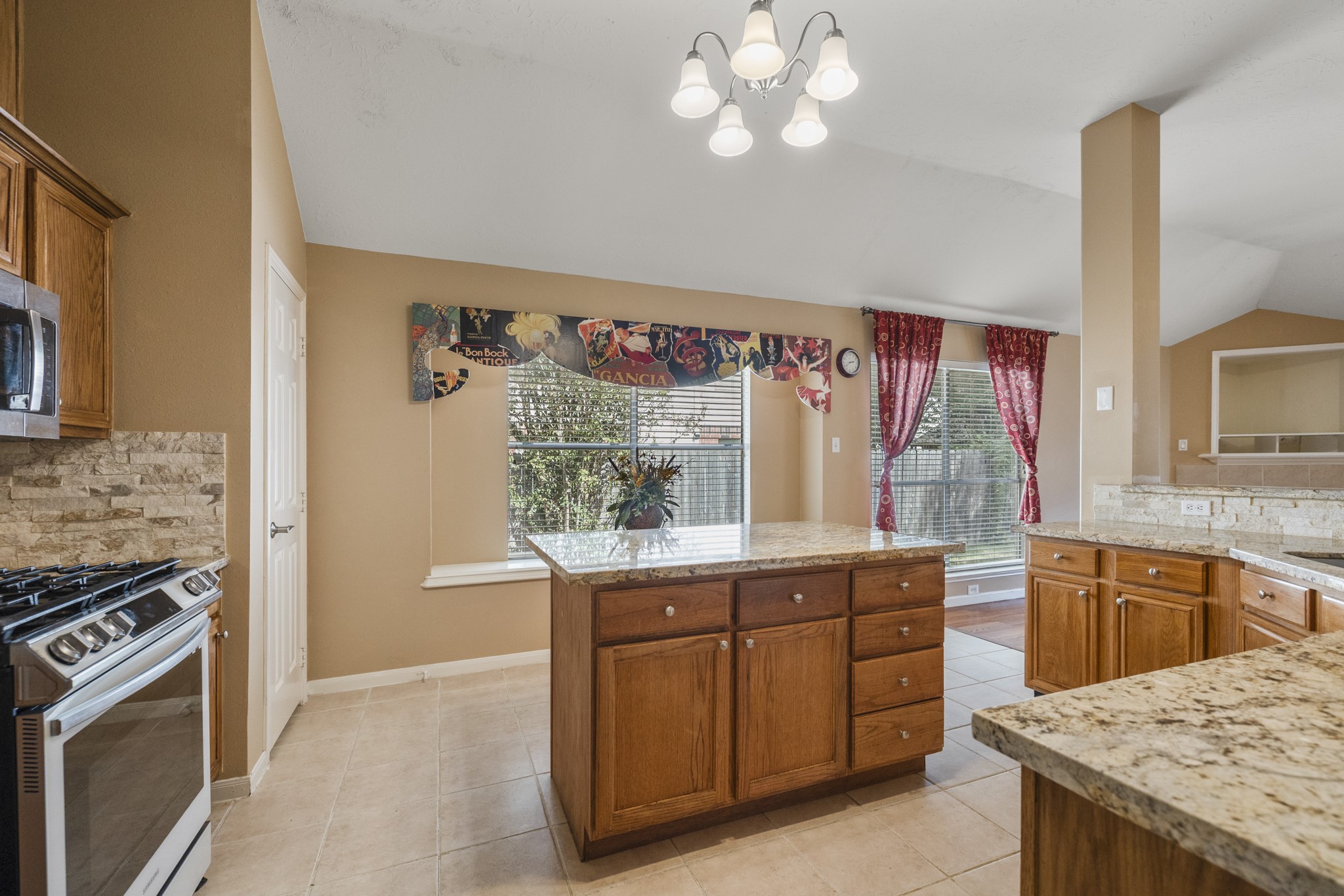 9109 Benwick Street Spring, TX 77379 - Photo 7 of 28 a kitchen with a stove and a kitchen island