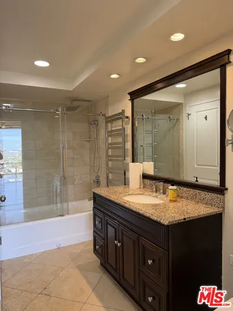 a bathroom with a granite countertop sink mirror and shower