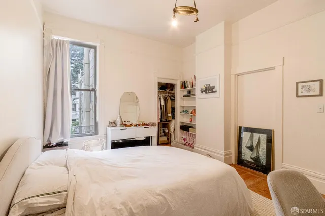 a bedroom with a bed and wooden floor