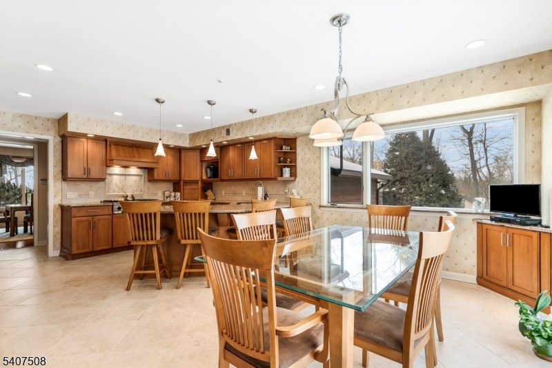 855 Sunset Ridge Bridgewater, NJ 08807 - Photo 14 of 39 a dining room with stainless steel appliances a dining table chairs a flat screen tv and a view of kitchen