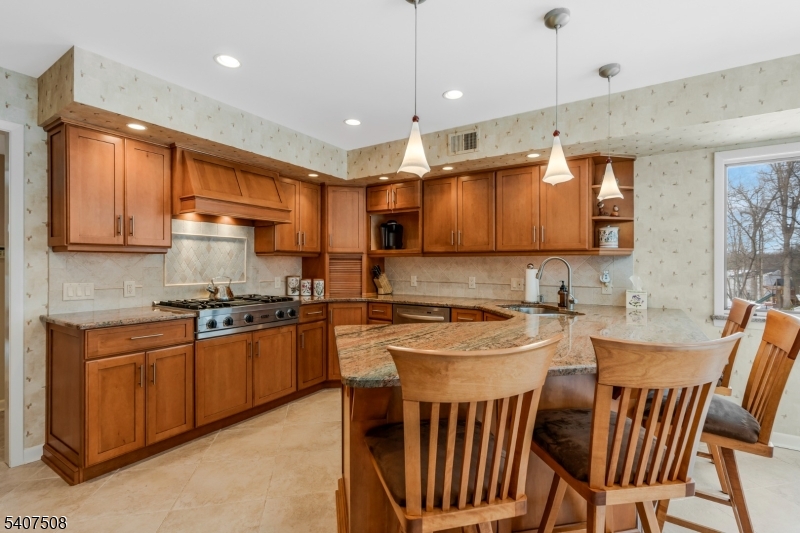 855 Sunset Ridge Bridgewater, NJ 08807 - Photo 19 of 39 a kitchen with stainless steel appliances granite countertop a stove top oven a sink a dining table and chairs