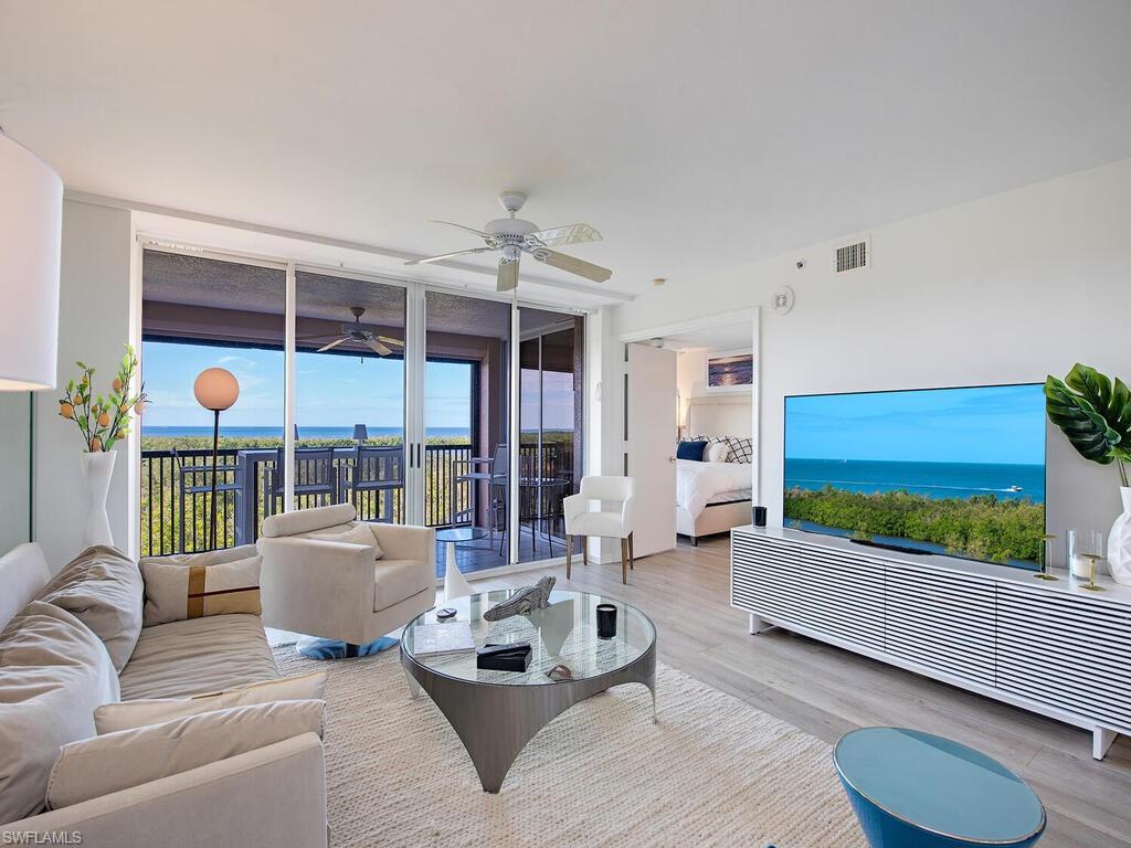 6825 Grenadier Boulevard, Unit 604 Naples, FL 34108 - Photo 2 of 12 a living room with furniture and a flat screen tv