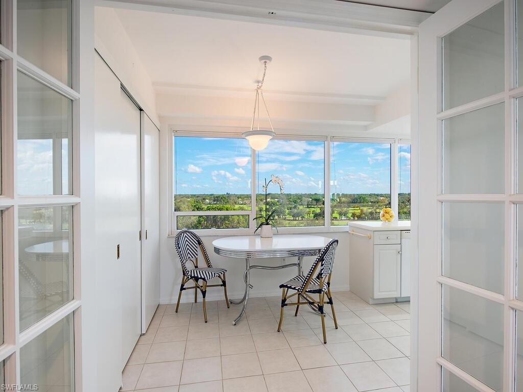 6825 Grenadier Boulevard, Unit 604 Naples, FL 34108 - Photo 6 of 12 a dining room with furniture a chandelier and window
