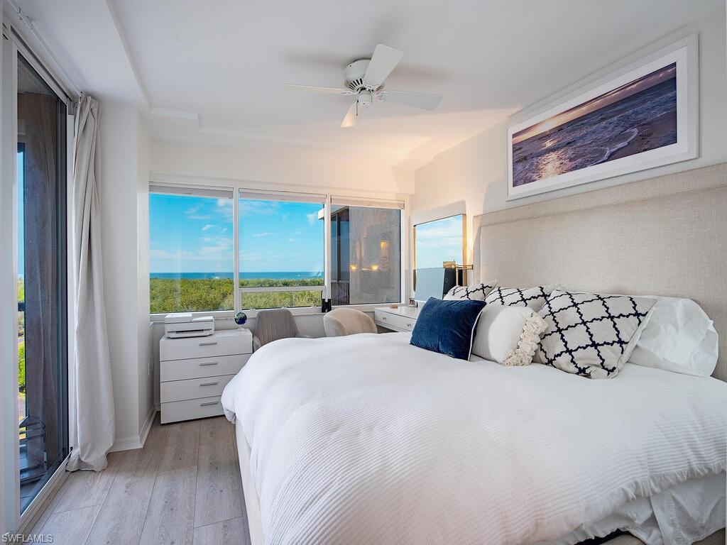 6825 Grenadier Boulevard, Unit 604 Naples, FL 34108 - Photo 10 of 12 a bedroom with a large bed and a large window