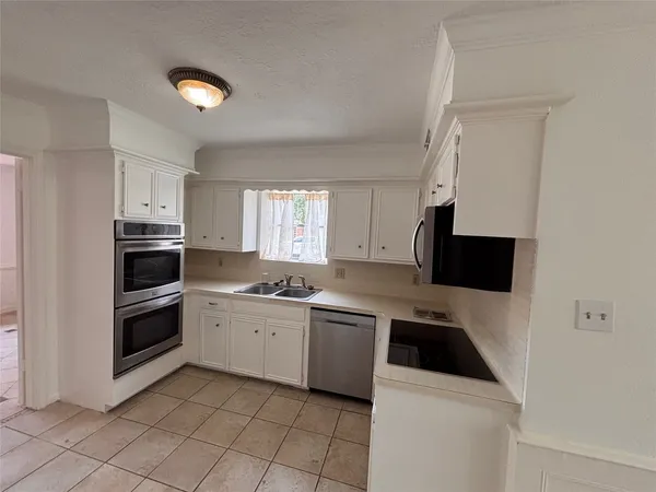 a kitchen with a sink and white cabinets