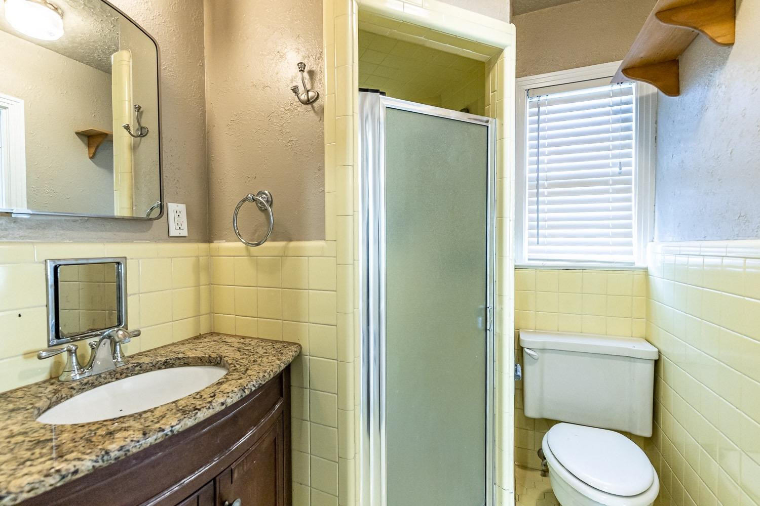 3708 27th Street Lubbock, TX 79410 - Photo 16 of 23 a bathroom with a granite countertop sink toilet and shower
