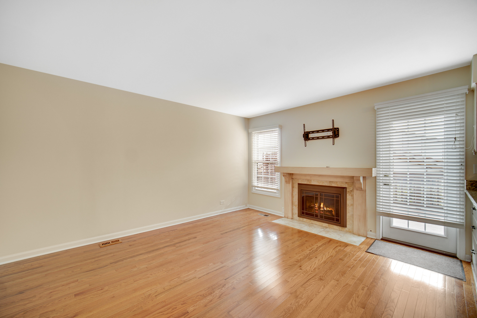 1130 Oakview Drive Wheaton, IL 60187 - Photo 12 of 25 a view of an empty room with wooden floor fireplace and a window