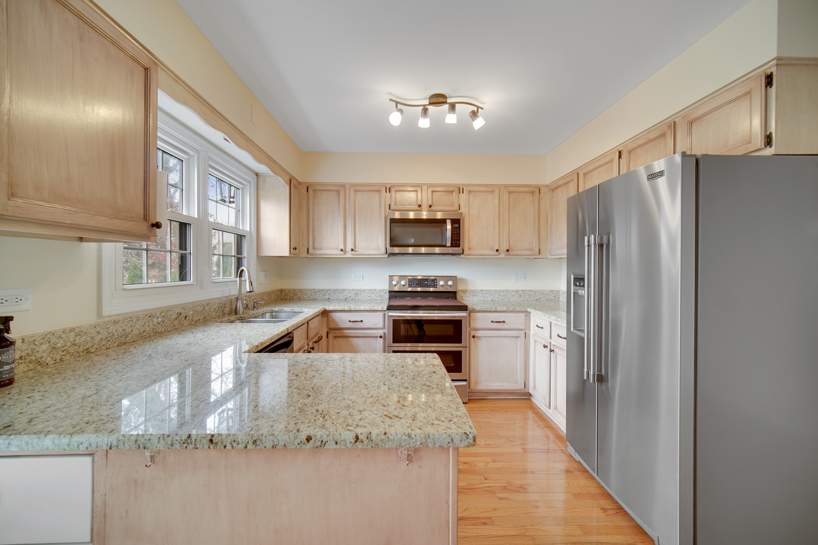 1130 Oakview Drive Wheaton, IL 60187 - Photo 8 of 25 a kitchen with granite countertop a refrigerator a sink a stove a microwave and island