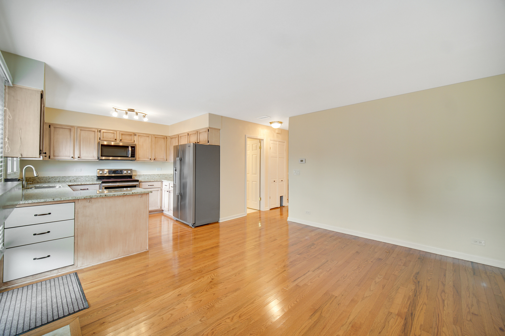 1130 Oakview Drive Wheaton, IL 60187 - Photo 10 of 25 a kitchen with granite countertop a refrigerator stove and white cabinets with wooden floor