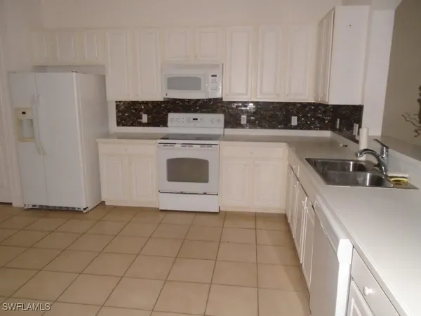 a kitchen with a sink a stove and cabinets