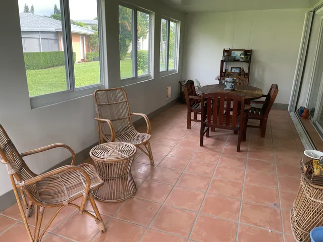 a palm tree sitting in front of a house with a yard