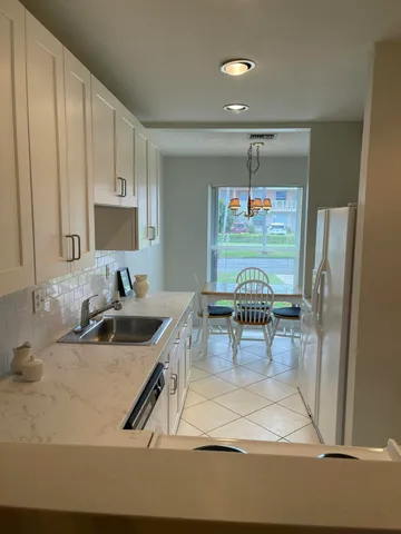 a kitchen with stainless steel appliances granite countertop a sink and a refrigerator