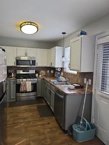 a kitchen with stainless steel appliances granite countertop a stove sink and cabinets
