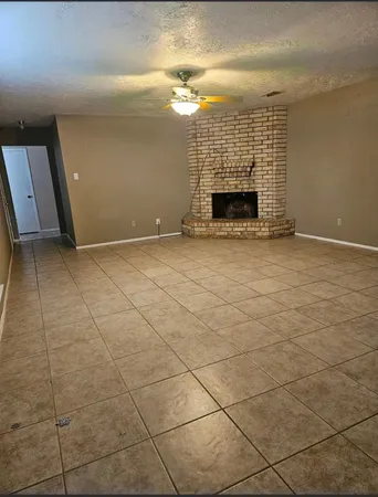 an empty room with a fireplace and a rug