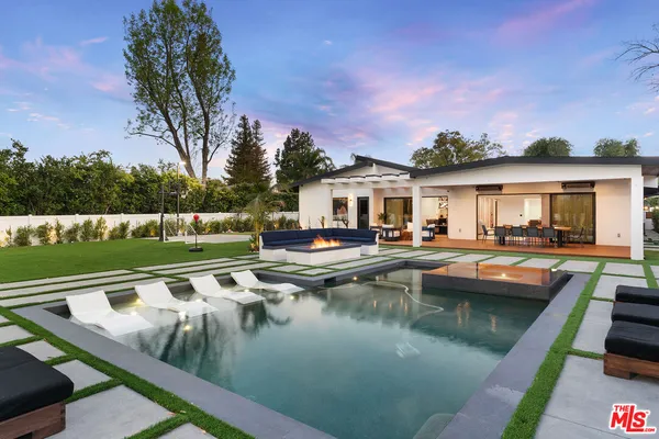 a view of an house with swimming pool and chairs