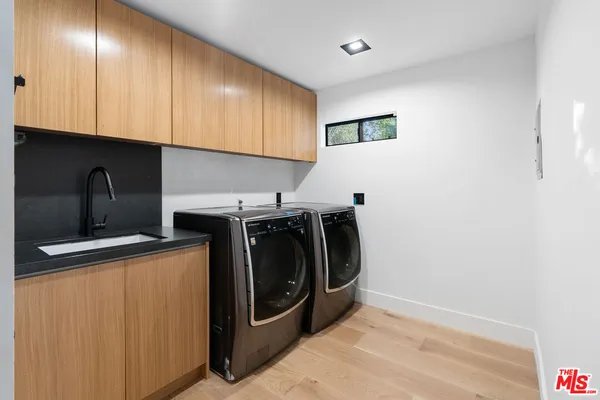 a utility room with sink dryer and washer