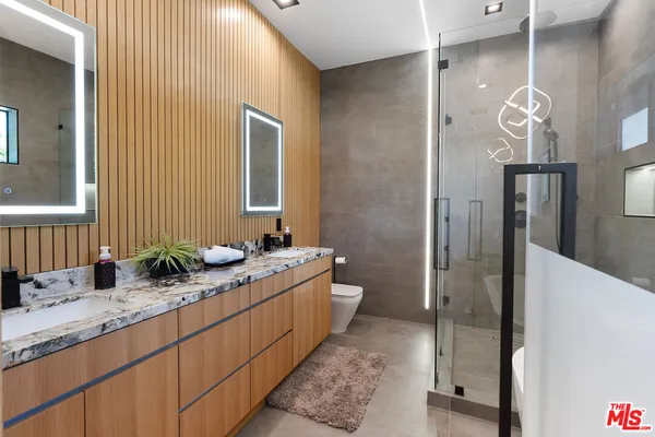 a bathroom with a granite countertop sink a mirror and a shower