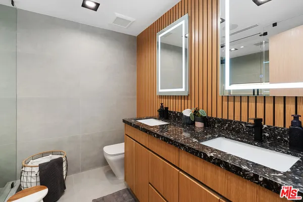 a bathroom with a granite countertop sink and a mirror