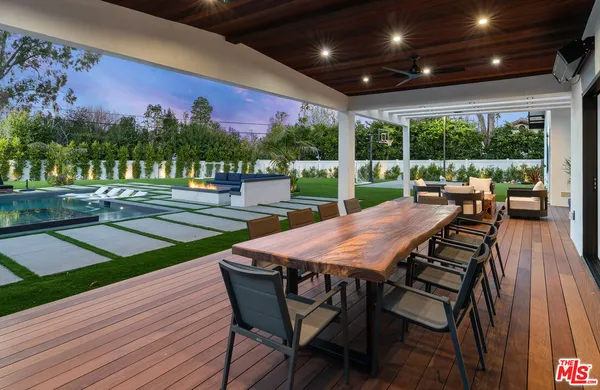 a view of a patio with table and chairs with wooden floor and fence